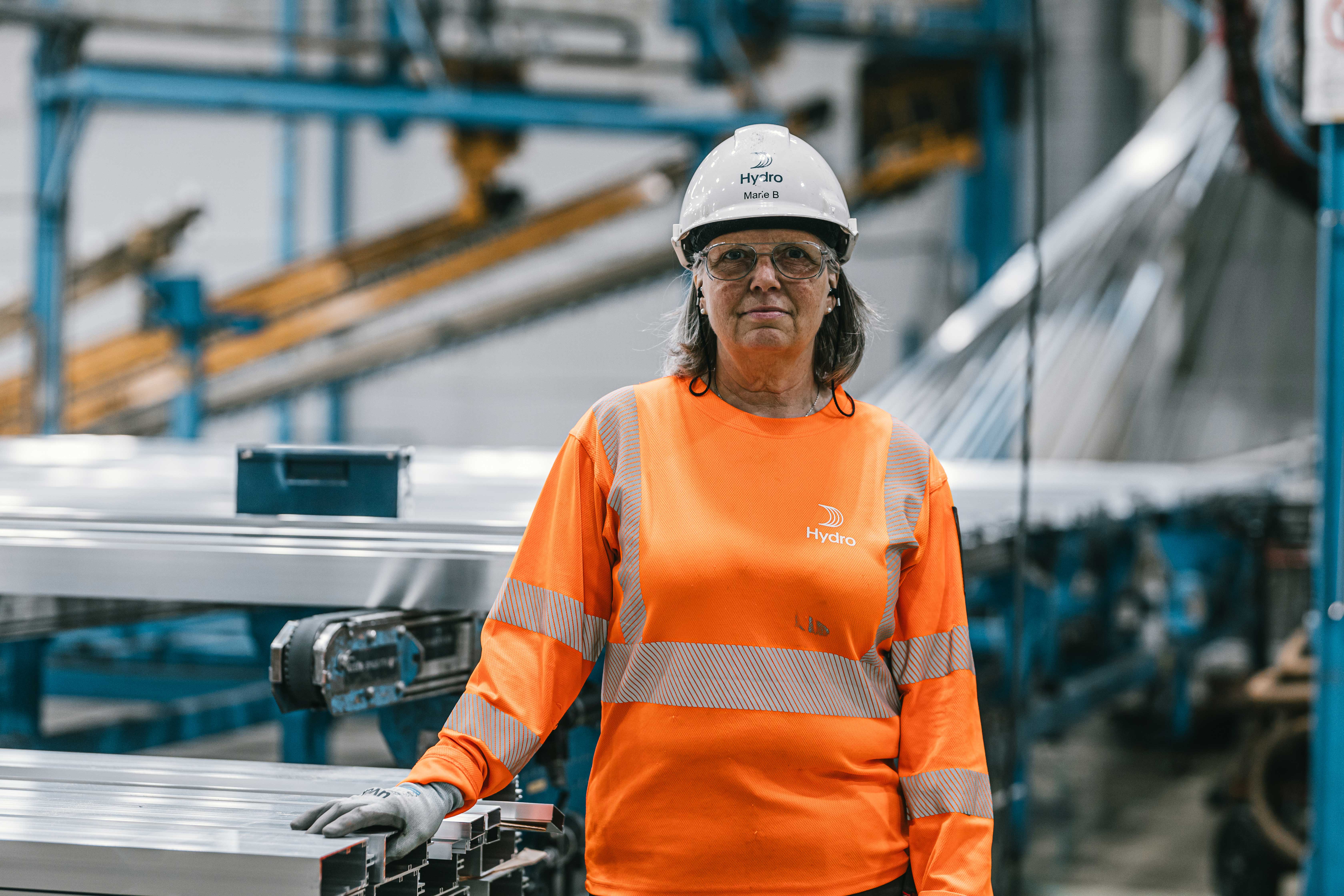 a woman wearing a hard hat and orange shirt