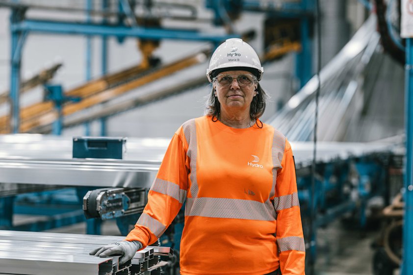 a woman wearing a hard hat and orange shirt
