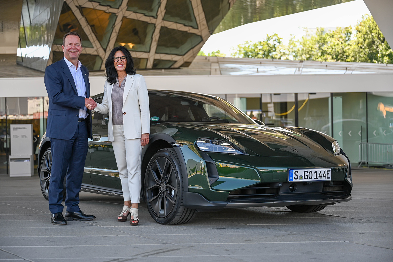 a man and woman standing next to a car