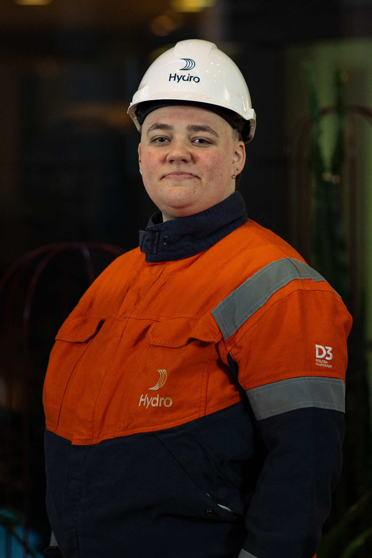a woman wearing a hard hat and orange jacket