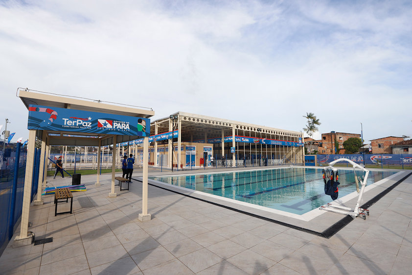 a swimming pool with people standing in front of it
