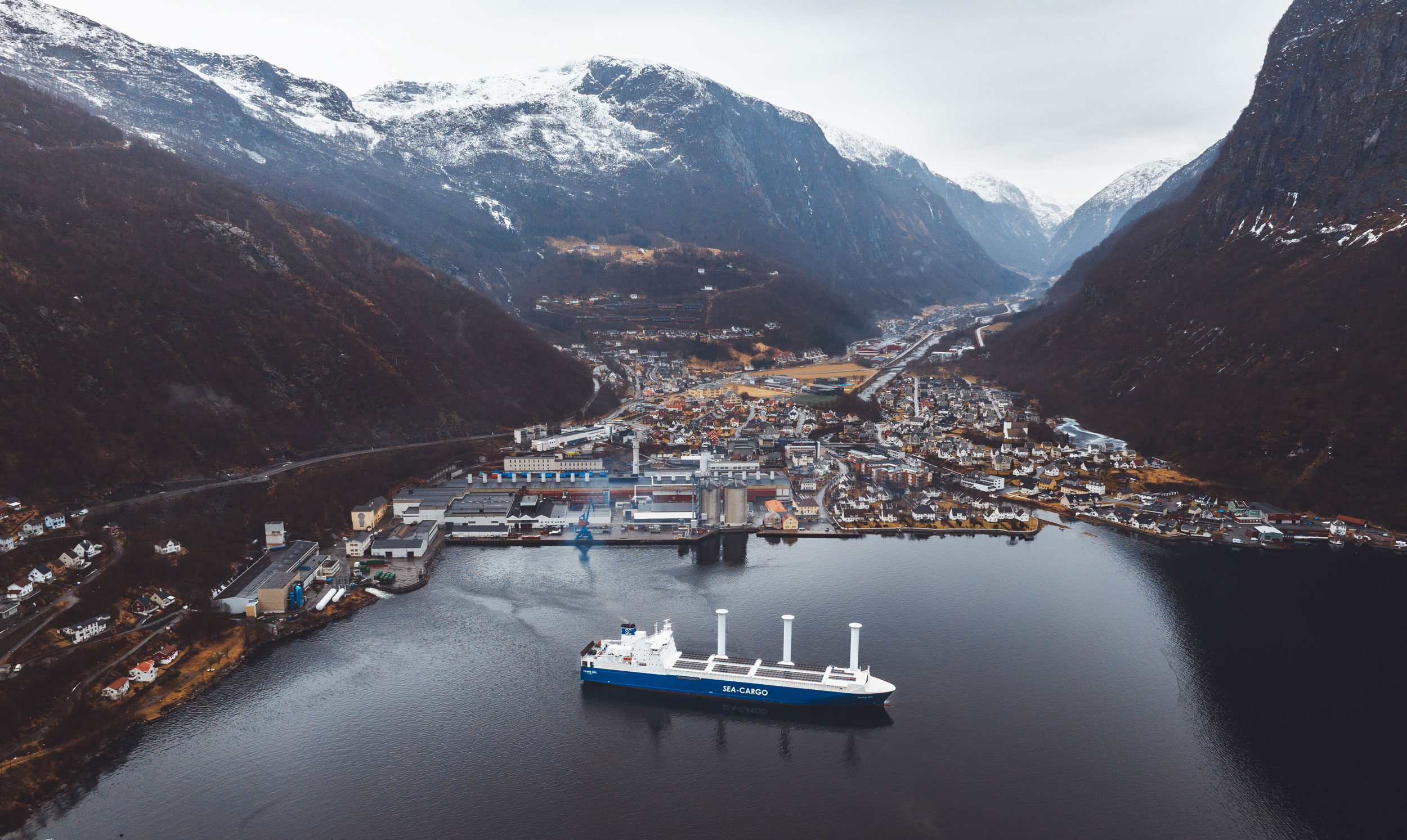a ship in a body of water with mountains in the background