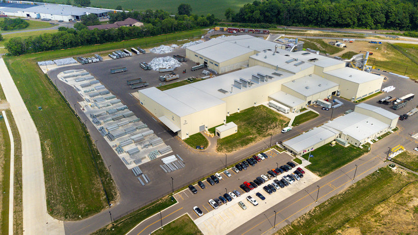 a large warehouse with many cars parked in a parking lot