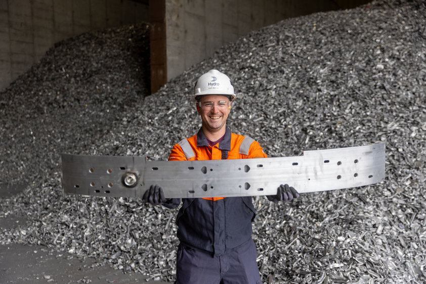 a man in a hard hat holding a large piece of metal