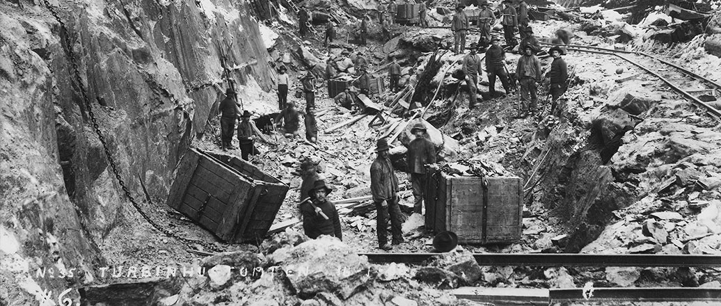 A group of workers doing construction work on a hillside.