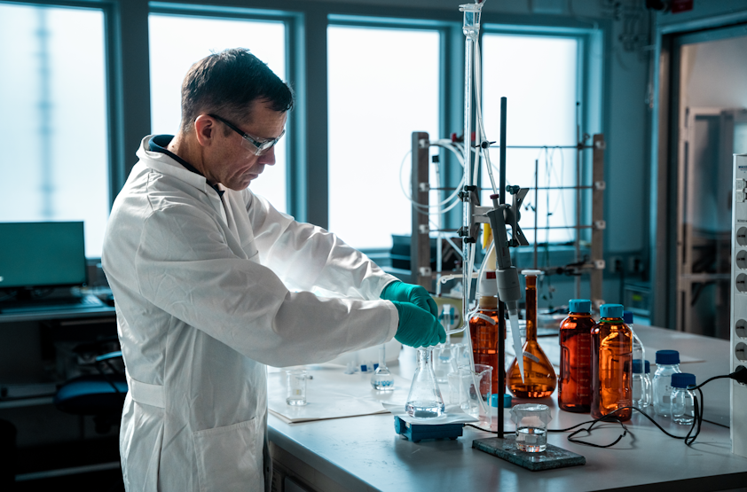 a man in a lab coat and gloves