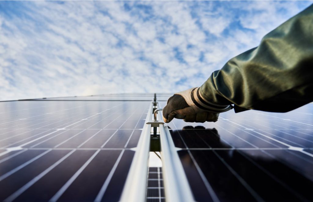 a person's hand on a solar panel