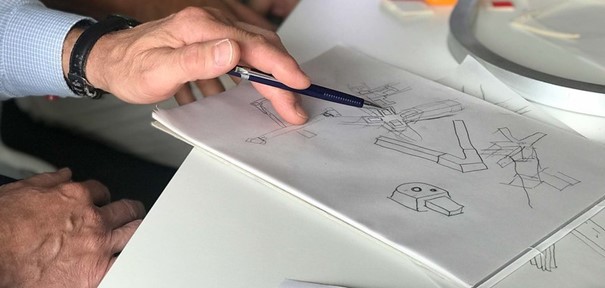 Hand hält Stift über gezeichneten Illustrationen