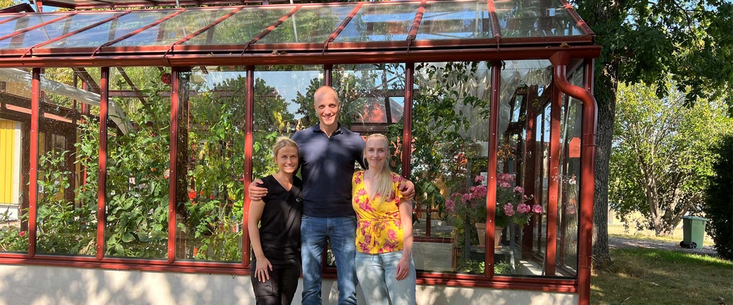 a group of people posing for a photo in front of a red building